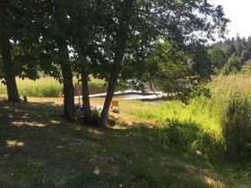 En liten lugn badplats och gräs nära Hackefors