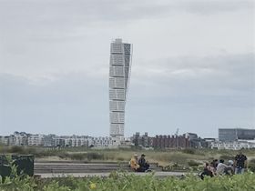 Cyklar utmed stranden och närmar mig Turning Torso
